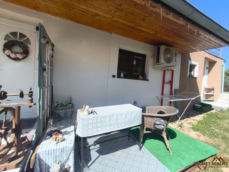 Terrace of a family house in Divín with a canopy, table, and rattan chair.