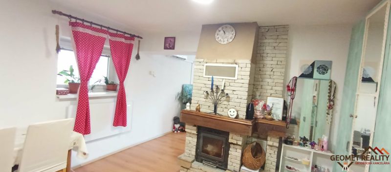 Living room in a family house with a fireplace and decorative furniture, floor with wooden decor.