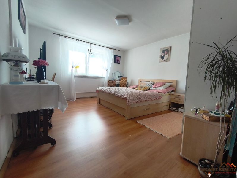 A bedroom in a family house with a bed and a wooden decor floor.