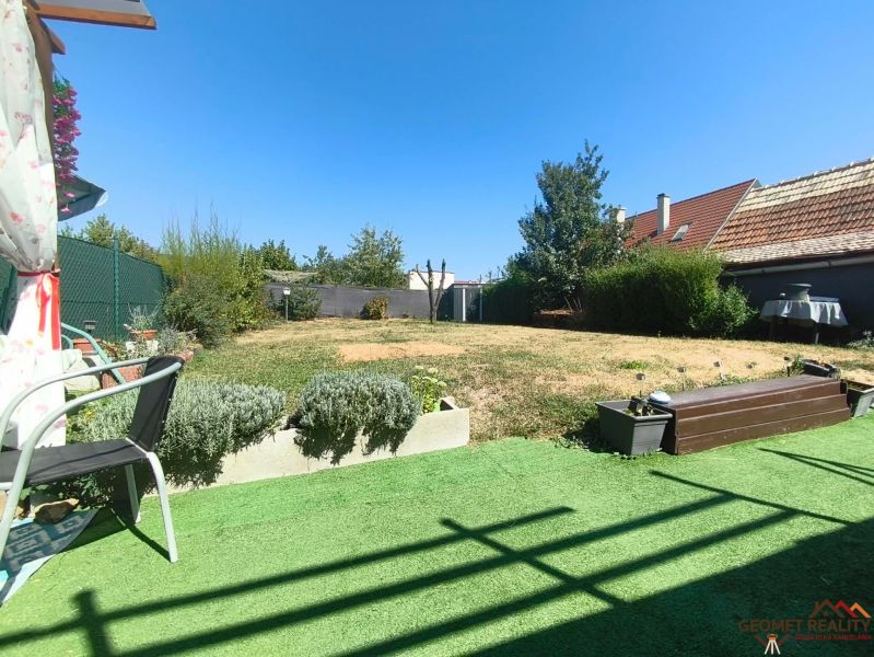 The garden of a family house in Divín with a lawn and a terrace for sitting.