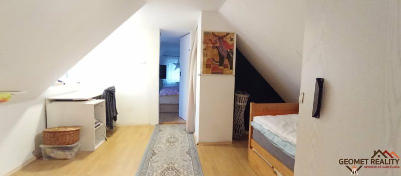 Attic hallway in a family house with a wooden decor floor and carpet.