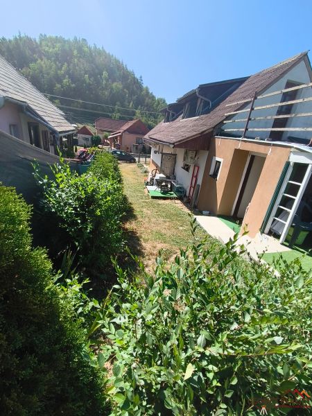 Family houses in Divín surrounded by greenery and blue skies.