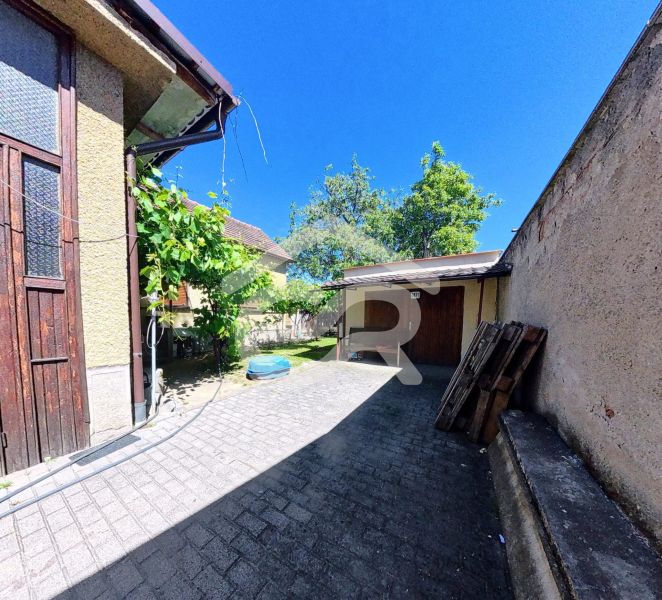 Courtyards of family houses on Sládkovičova Street in Zlaté Moravce surrounded by greenery and paved with tiles.