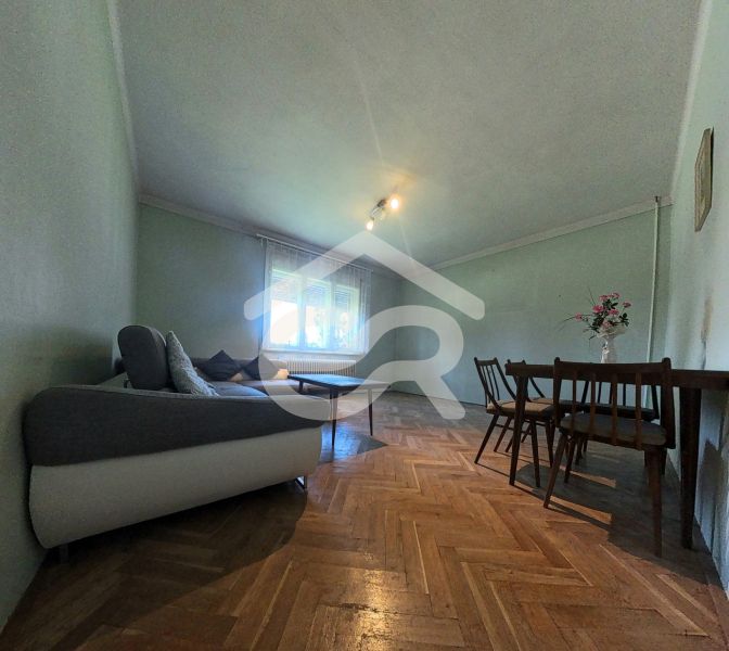 Living room in a family house with a sofa, table, and wooden decor flooring.
