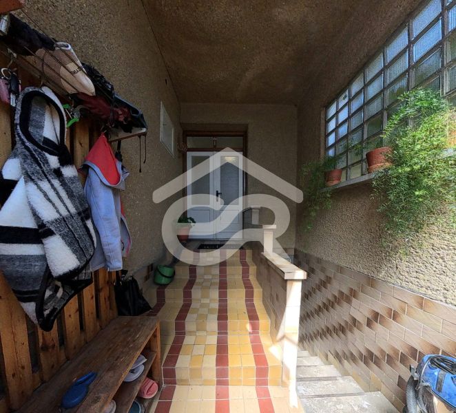 Entrance area of a family house with jackets and potted plants.