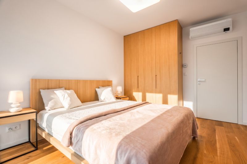 A bedroom with a double bed, a wardrobe, and a wooden decor floor in a two-room apartment.