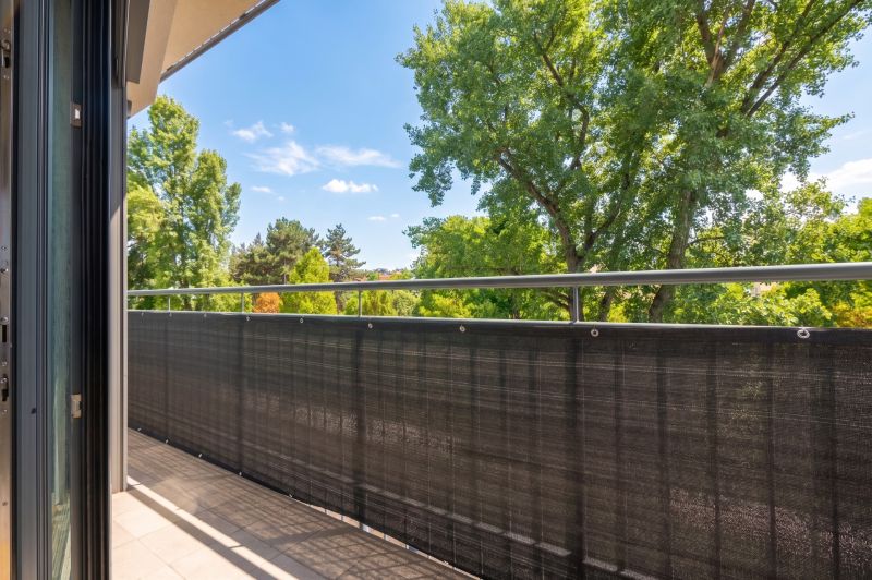 A balcony with a view of green trees in a 2-room apartment.