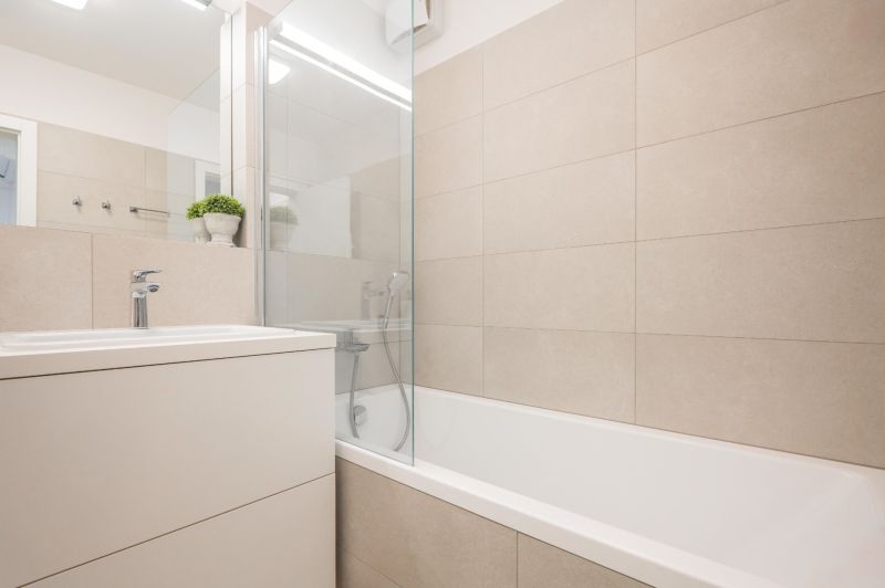 A bathroom with a bathtub and a sink in a 2-room apartment, bright tiles.
