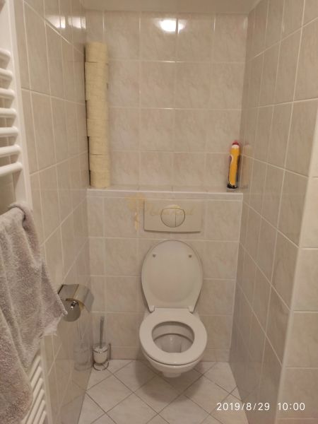 Bathroom with toilet, paper holder, and towel rack in a 2-room apartment.