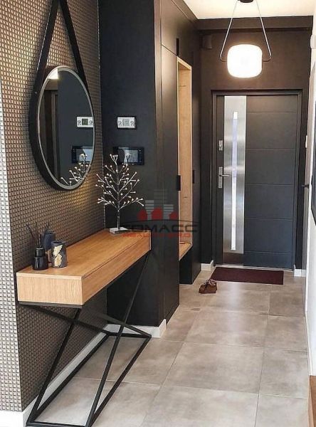 Entrance hall with a round mirror, wooden console, and decorative elements in a family house.