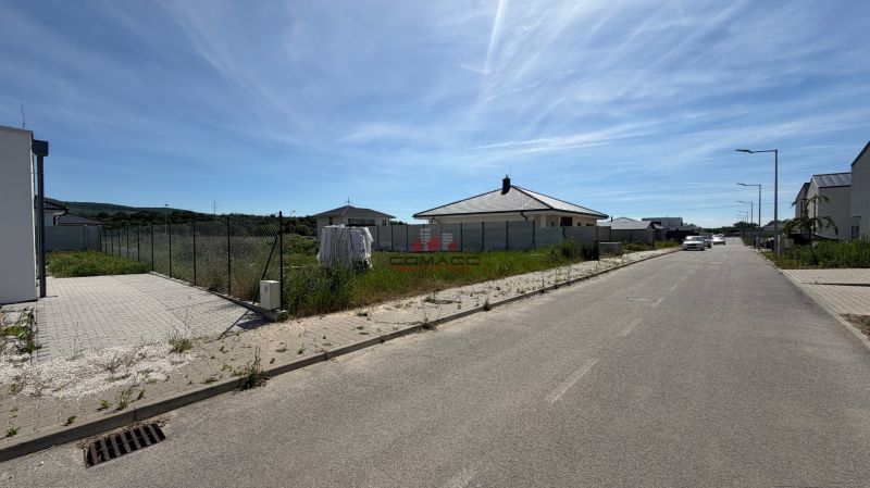 Ducovská Street in Moravany nad Váhom with a family house, cars, and fences.