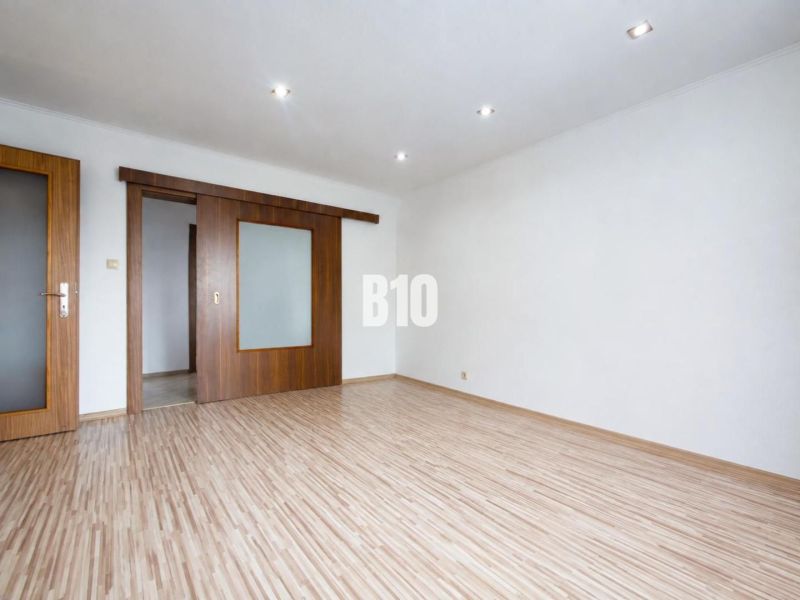 A bright interior with sliding doors and a wood-decor floor in a 3-room apartment.