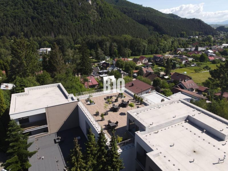 A view of the rooftop terrace between buildings surrounded by nature in Rajecké Teplice on M. R. Štefánika Street.
