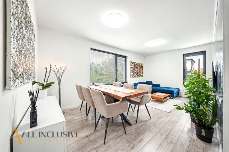 Living room with a dining table, sofa, and wood-patterned flooring in a 3-room apartment.