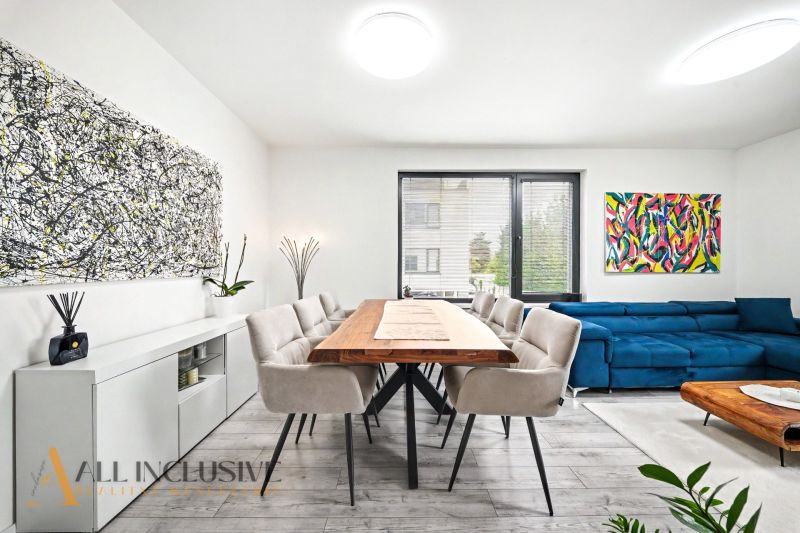 A spacious living room with a wooden table and comfortable seating in a 3-room apartment.