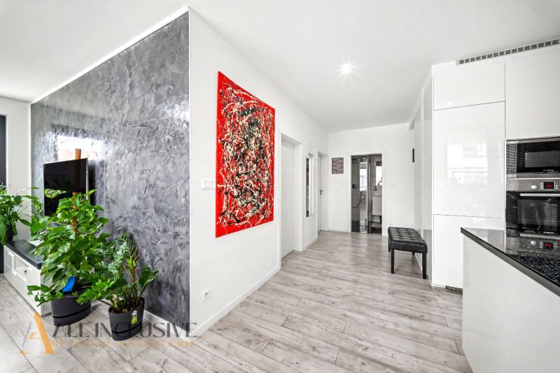 Interior of a 3-room apartment with a wooden decor floor, modern accessories, and houseplants.