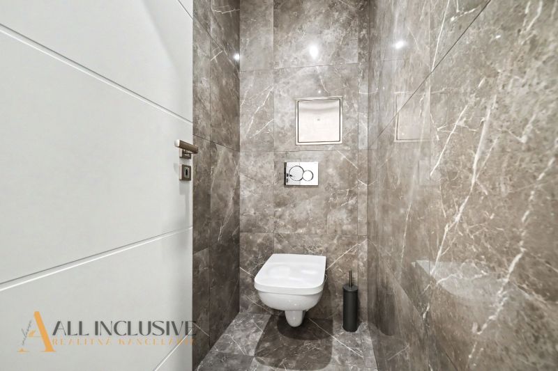 Bathroom with a wall-mounted toilet and marble walls in a 3-room apartment.