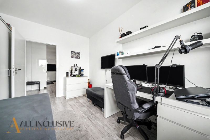 A study with a computer, shelves, and a wooden decor floor in a 3-room apartment.