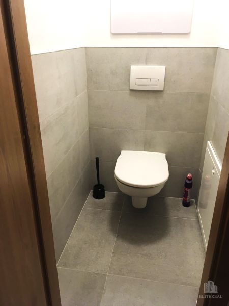 Bathroom in a 2-room apartment with tiles and a wall-hung toilet.