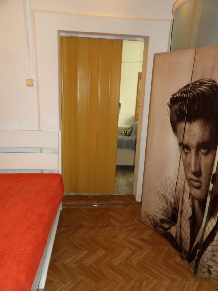 A room in a 2-room apartment with a bed, a floor with a wooden decor, and sliding doors.