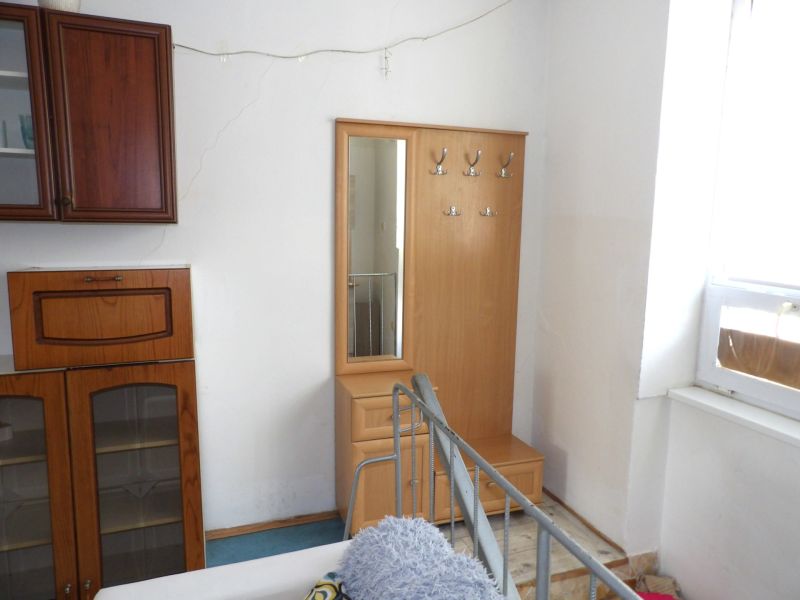 In a 2-room apartment, there is a coat rack with a mirror and a storage cabinet.