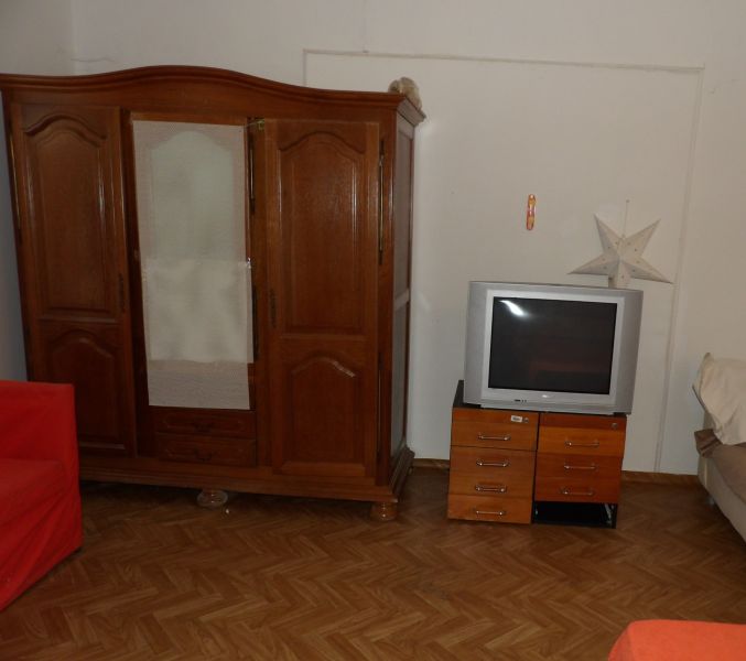 A room in a 2-bedroom apartment with wooden furniture and a wood-patterned floor.