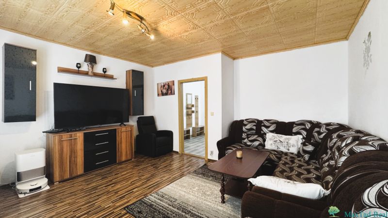 Living room with a sofa set and wood-patterned flooring in a 4-room apartment.