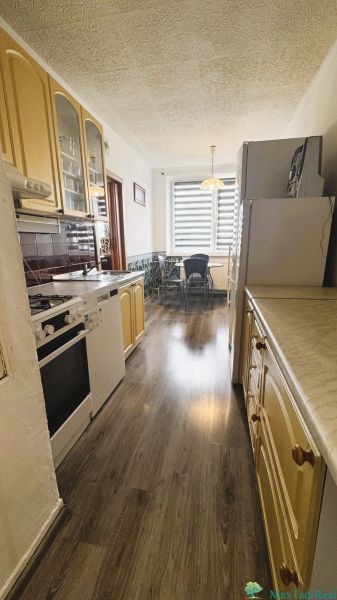A kitchen in a 4-room apartment with a kitchen unit and a floor with a wooden decor.