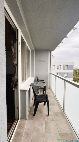 A balcony with plastic furniture at a 4-room apartment.