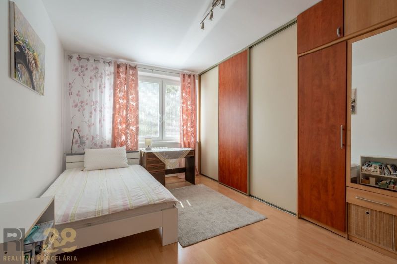 A bright room in a 3-room apartment with a large wardrobe and a desk.