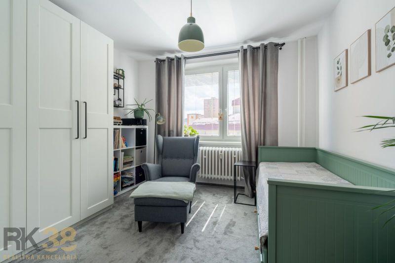 A bright room with a chair, bed, wardrobe, and decorations in a 3-room apartment.