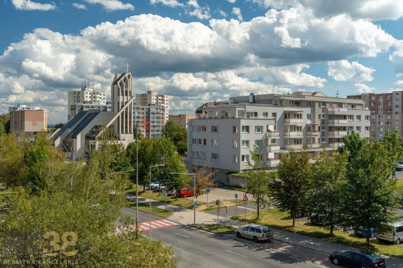 View of Ludvík Svoboda Street in Poprad with a sacral building and apartment blocks.
