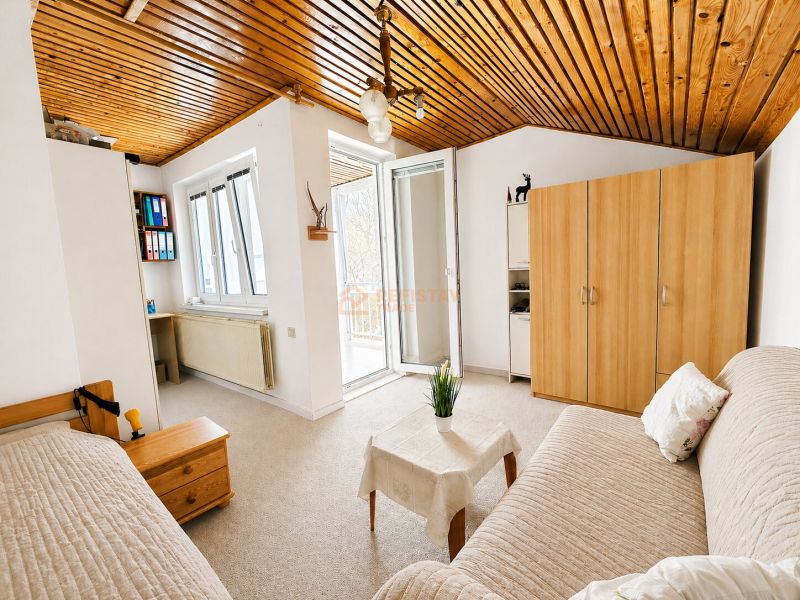 A bright room in a family house with a sofa set and a wardrobe.
