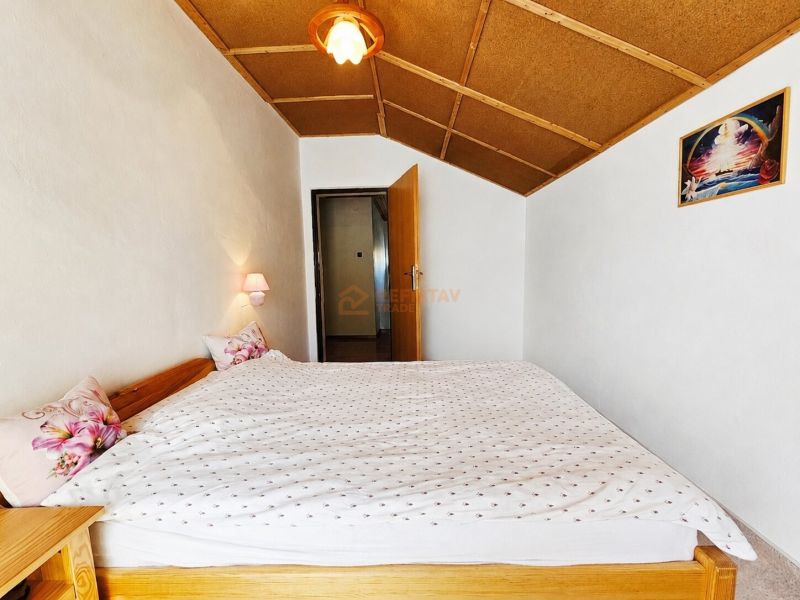 Bedroom in a family house with a double bed and wall lamps.