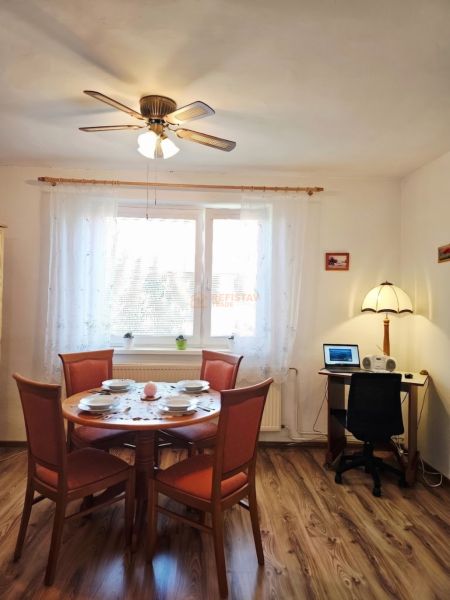 Dining room with a dining table, chairs, and wooden decor flooring in a family house.