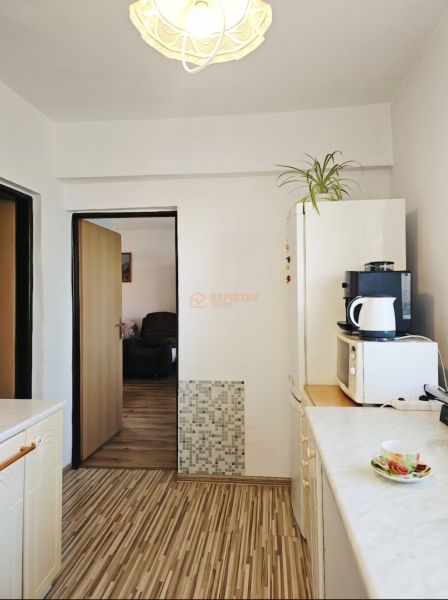 A kitchen in a family house with a wooden decor floor and appliances.
