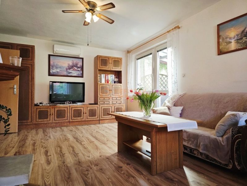 Living room in a family house with a wood-patterned floor and comfortable seating.
