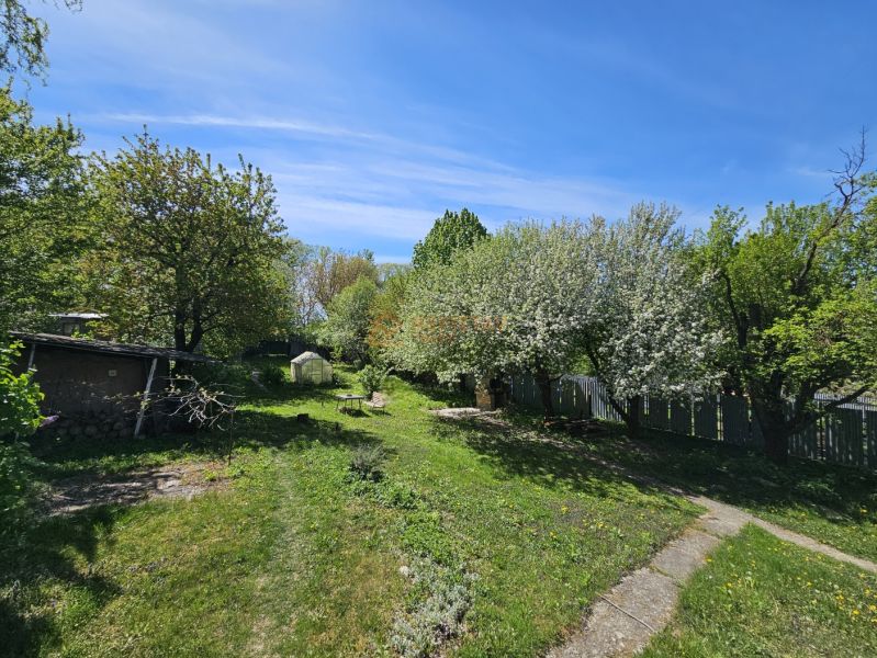 A garden at a family house in Nižná Hutka with a lawn, trees, and a gazebo.