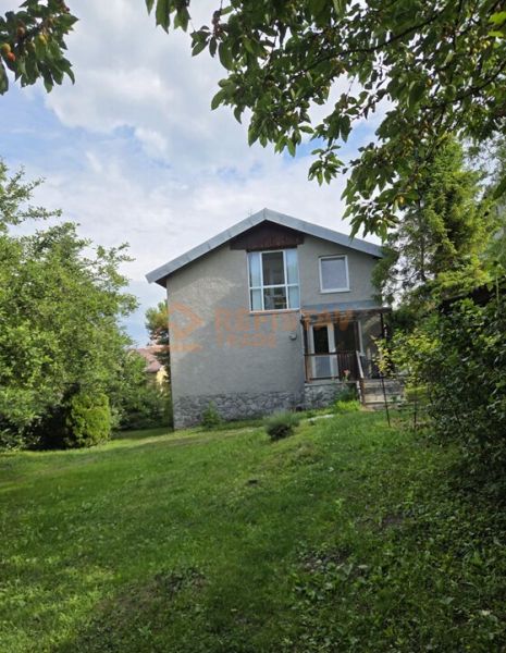 A family house in Nižná Hutka surrounded by greenery and trees.
