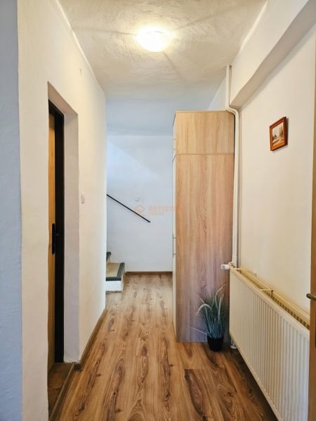 A hallway with a wood-patterned floor in a family house.