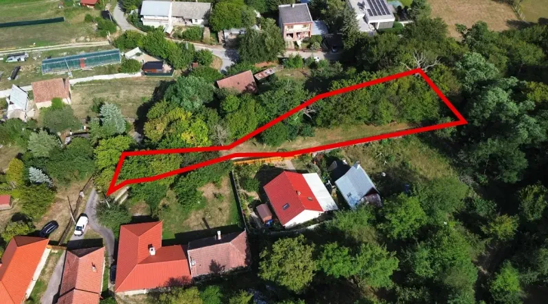 Aerial view of a plot in the gardens in Kolačno, surrounded by greenery and houses.