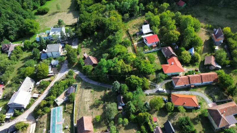 Aerial view of picturesque Gardens in Kolačno with scattered houses and greenery.