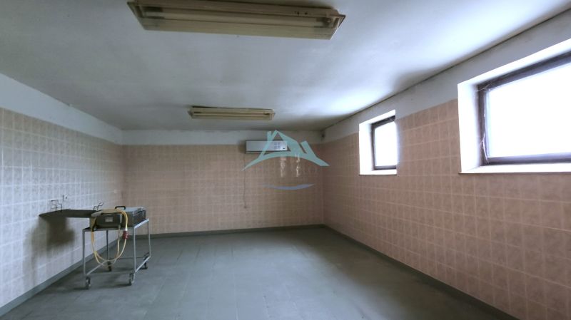 Production premises with tiles, low ceiling, and a sink.