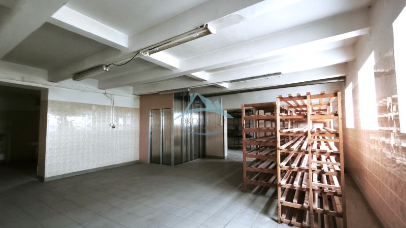 Manufacturing premises with a tiled floor, wooden shelves, and an elevator.