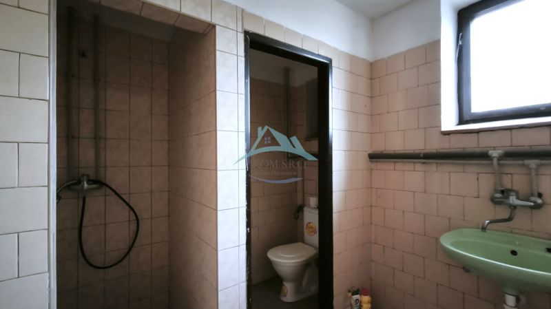 Bathroom in production facilities with toilet, sink, and shower.
