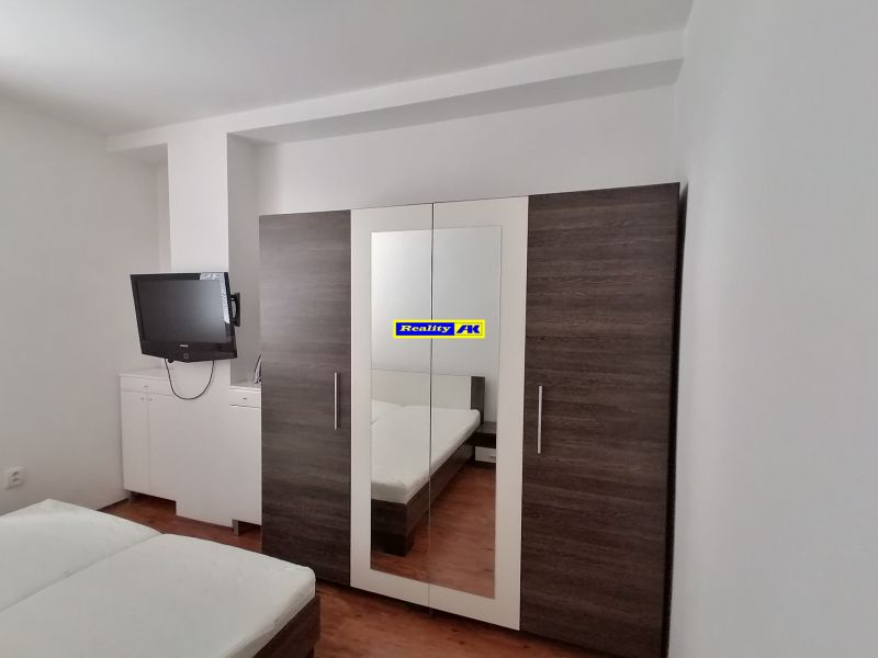 Bedroom with a TV, wardrobe, and bed, 2-room apartment.