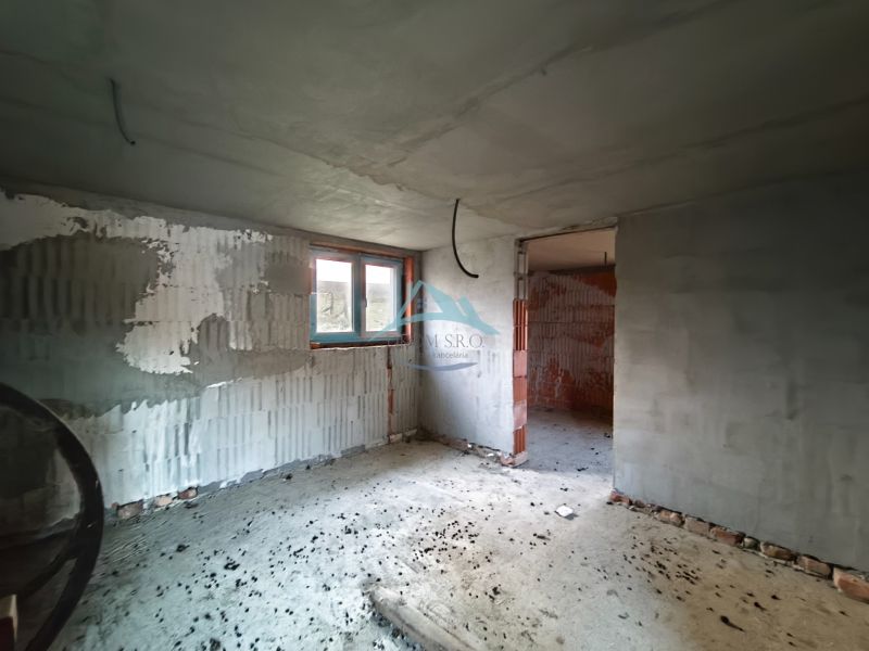 The interior of a family house under construction with unfinished plaster and concrete floor.