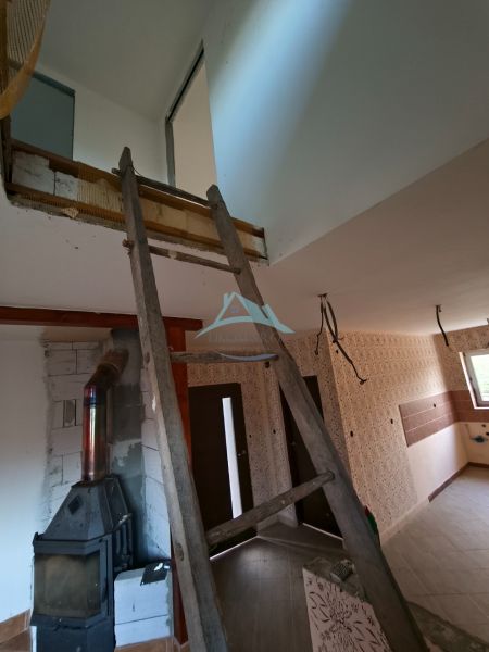 Interior renovation in a family house, dominated by stairs and wood-burning stove.