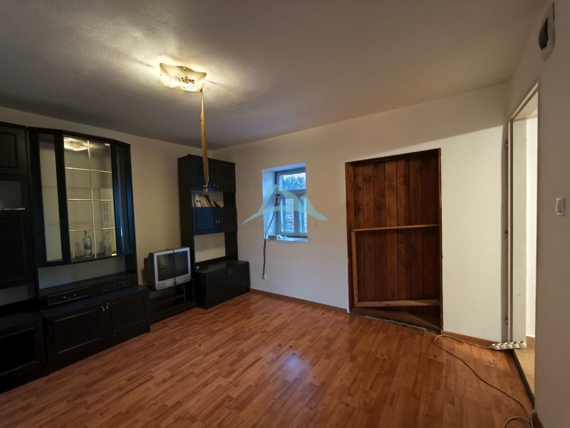 Living room with a dark wall unit and wooden decor flooring in a family house.