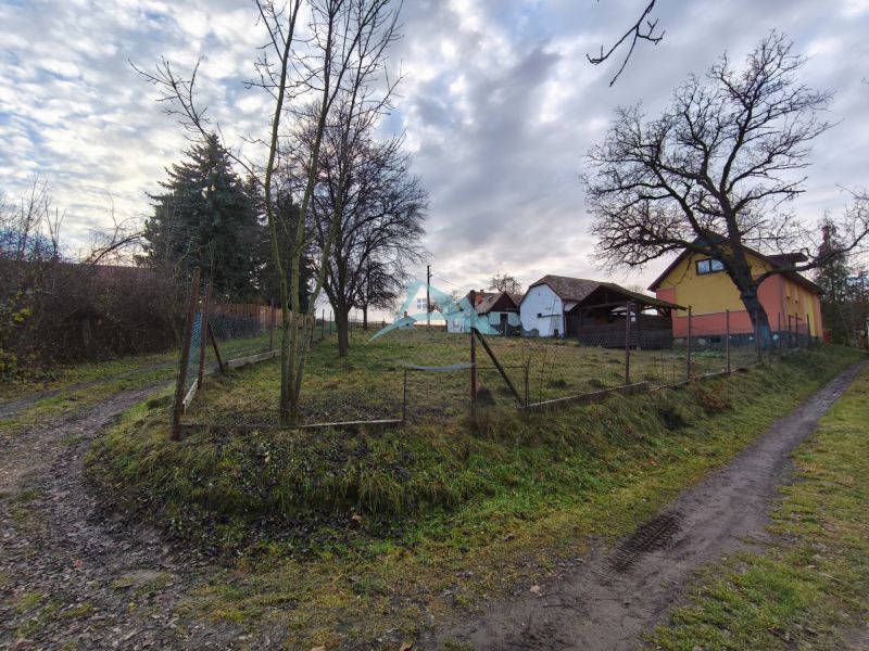 A family house on Prieloh in Dolná Strehová with a fenced garden, trees, and an access road.